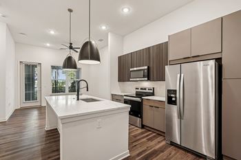 A modern kitchen with a white island and stainless steel appliances